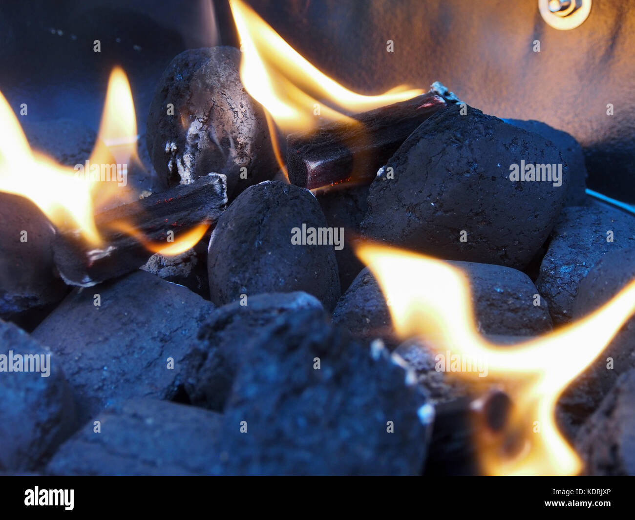 Charcoal briquettes in a barbeque being set alight by firelighters Stock Photo Alamy