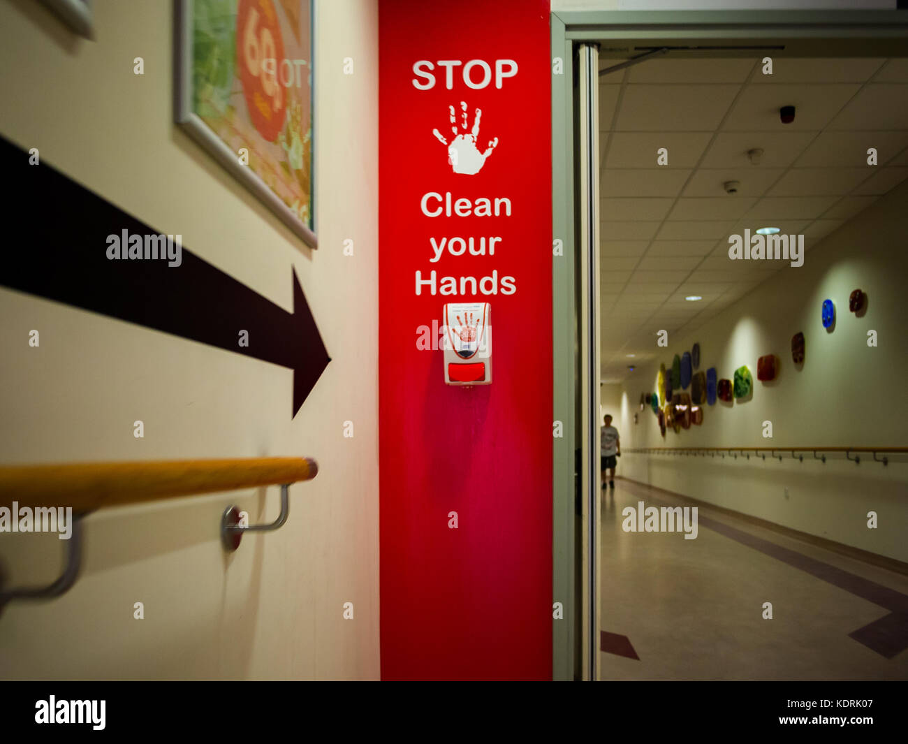 an Alcohol gel dispensing station for hand sanitising within a hospital with a warning sign. Stock Photo