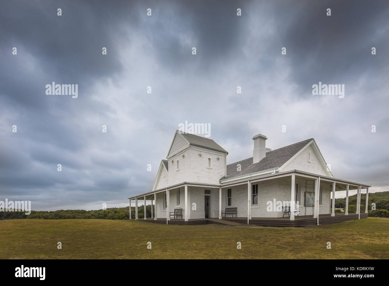 old stone farm house in the country with cloudy skies and green grass ...