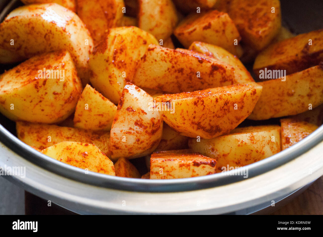 potato wedges with spices and thyme on a metal baking sheet. Top view Stock Photo