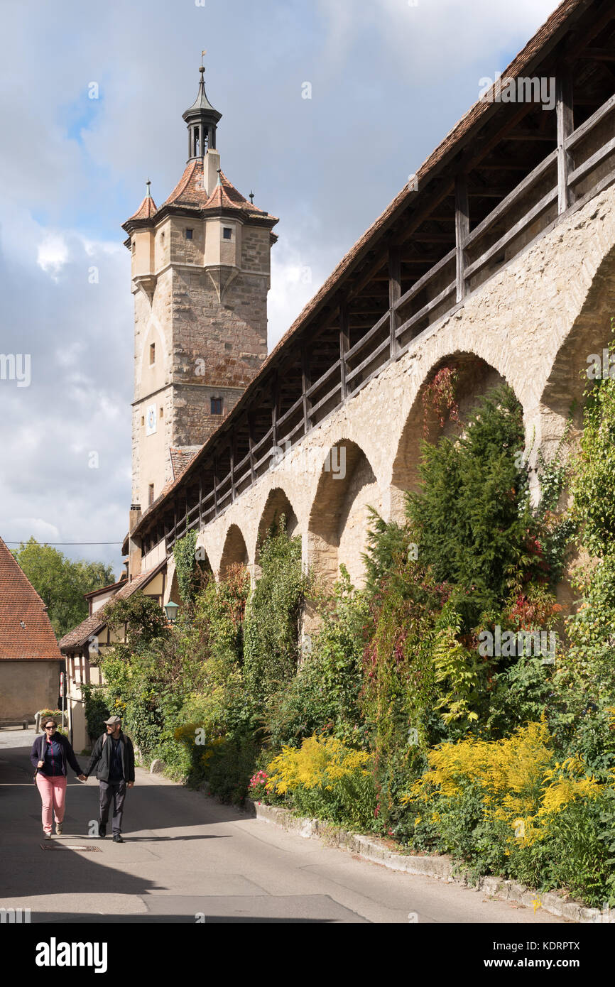 Couple walking beside the town walls, Rothenburg ob der Tauber, Bavaria, Germany, Europe Stock Photo