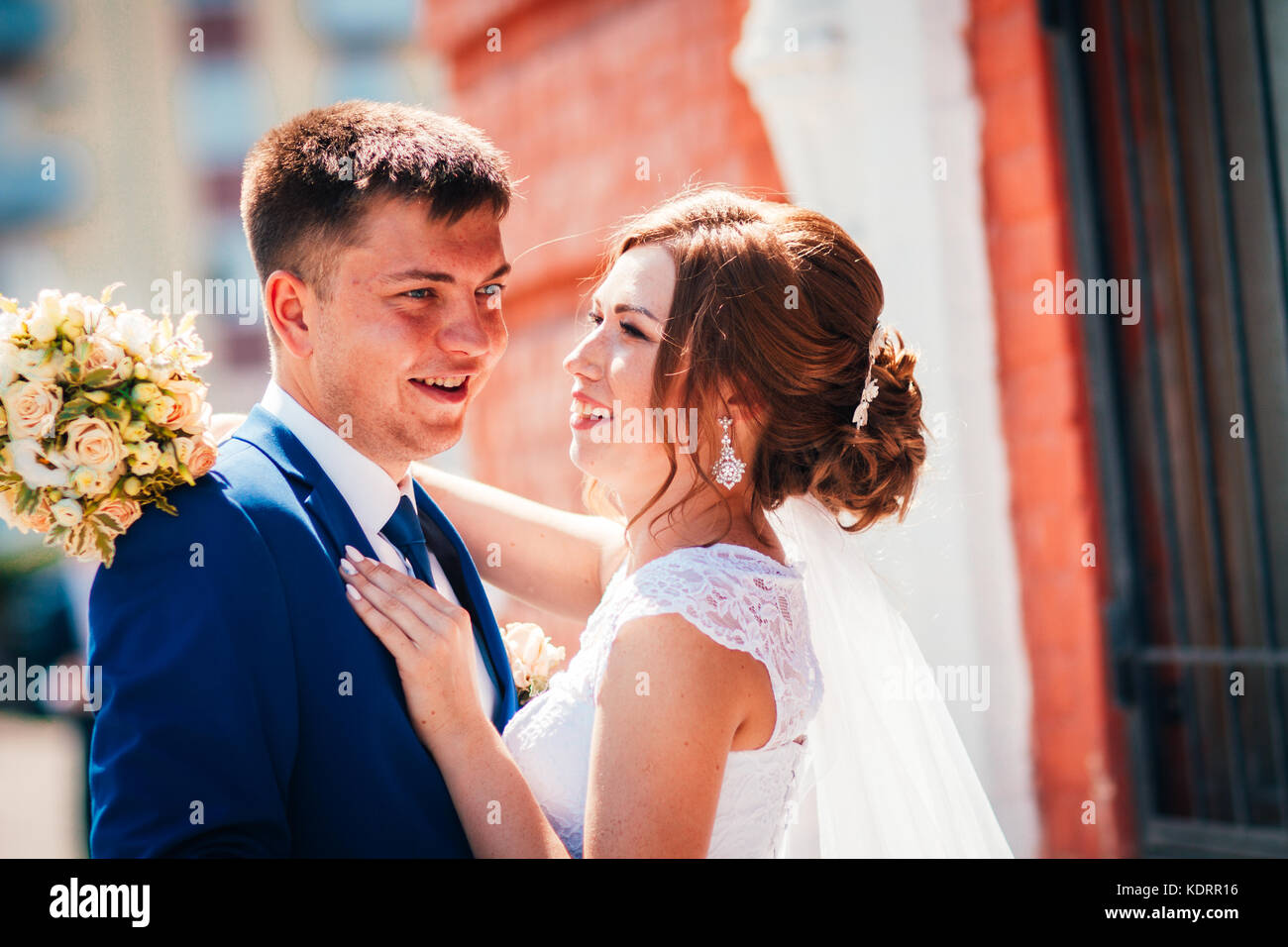 Bride and groom embracing on city background Stock Photo - Alamy