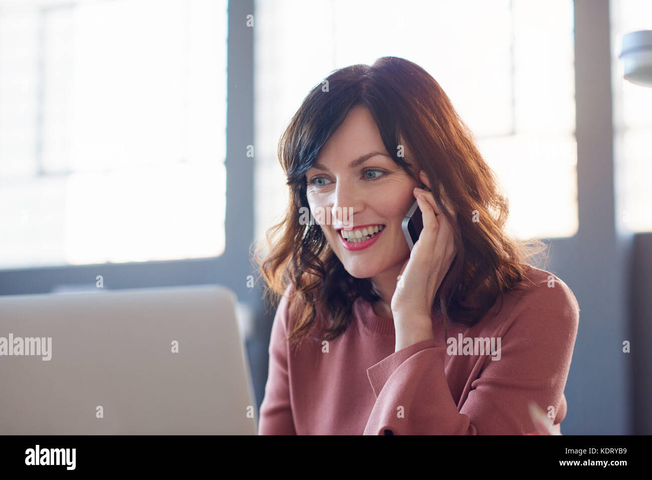 Smiling businesswoman working at her desk in a modern office Stock ...