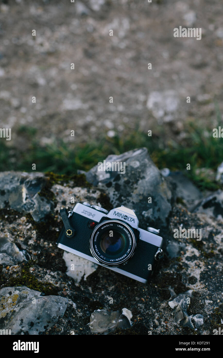 A Minolta XG-1 film camera laying face up on a rock, UK Stock Photo