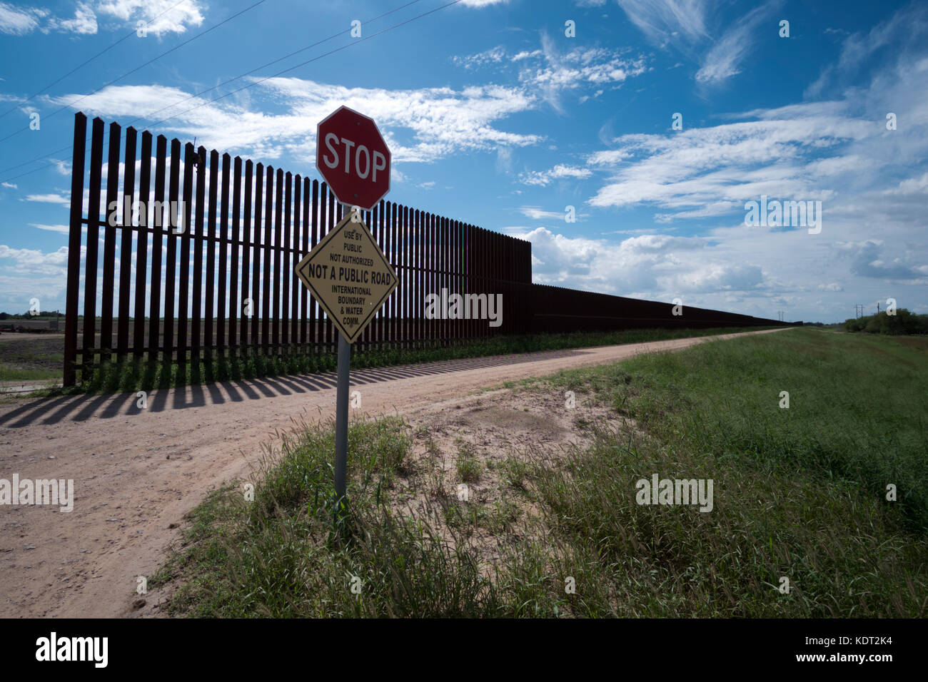 Texas border fence sits atop a dike near the Texas/Mexico border. This portion of the fence was built during the George W. Bush era. The fence and dik Stock Photo