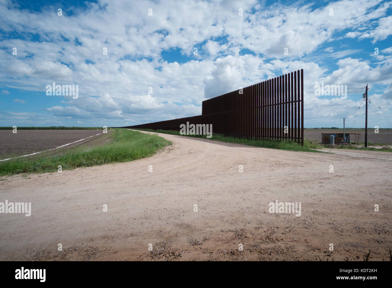 Texas border fence sits atop a dike near the Texas/Mexico border. This portion of the fence was built during the George W. Bush era. The fence and dik Stock Photo