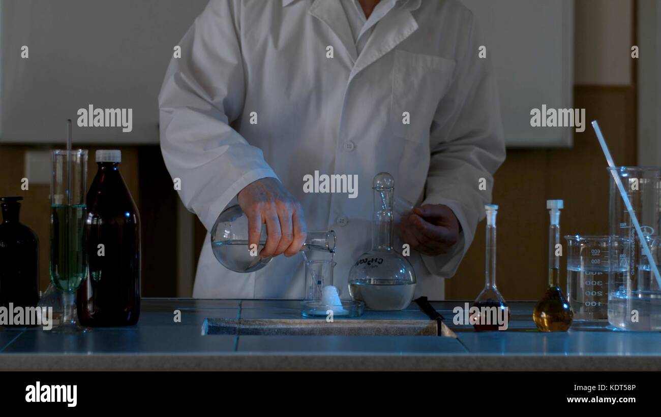 Chemical reaction. Measuring glass with ice on a table of a chemical