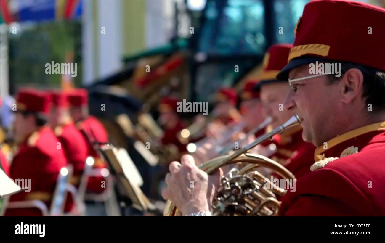 Russia, Moscow - 12 June 2017: Bandmaster playing on a trumpet. Bandwalas playing on their instruments in the park. Men in red play the trumpet closeup. Stock Photo