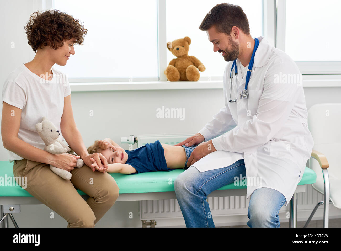 Pediatrician Palpating Stomach of Little Child Stock Photo