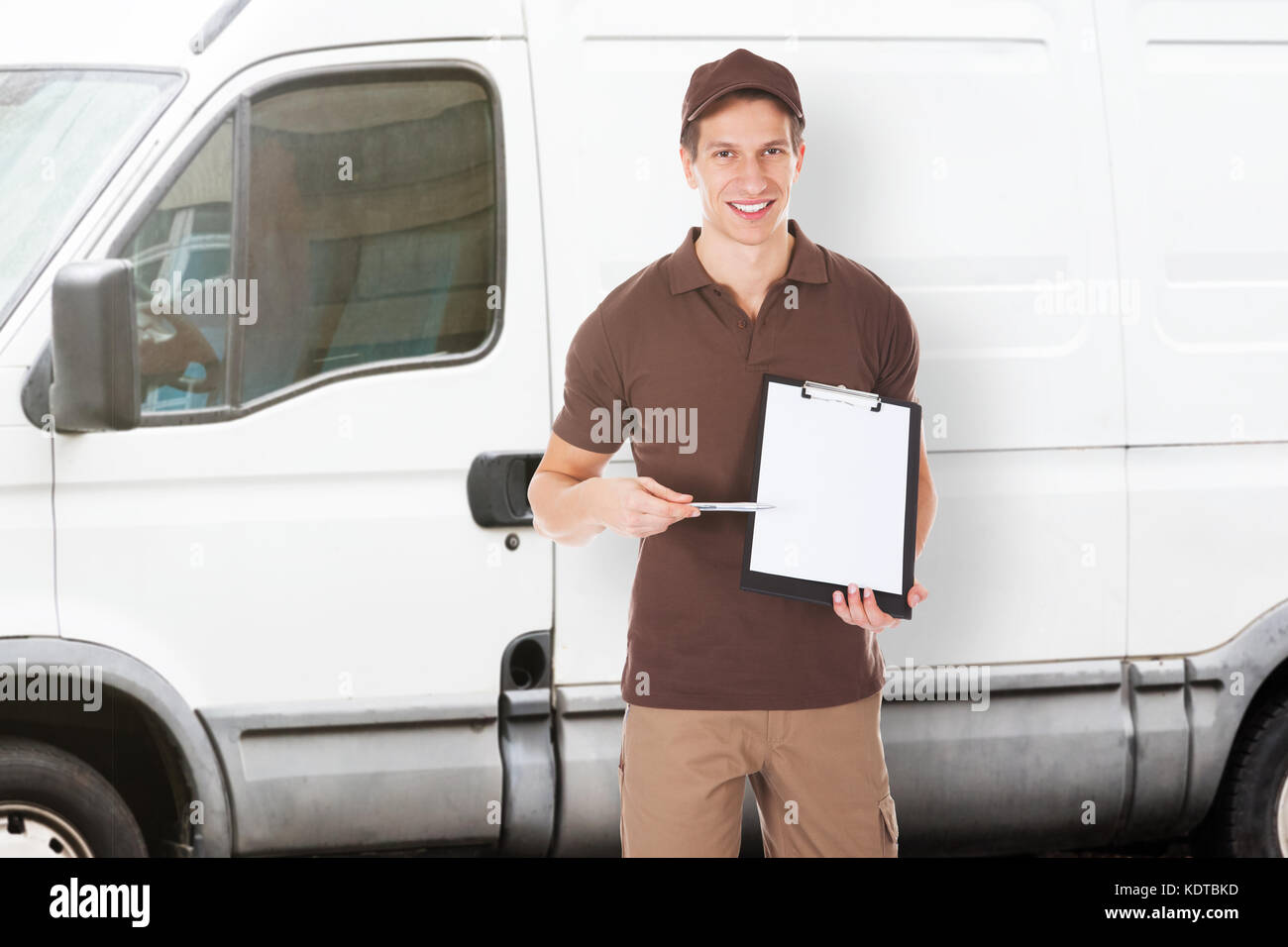 Smiling delivery man pointing hi-res stock photography and images - Alamy