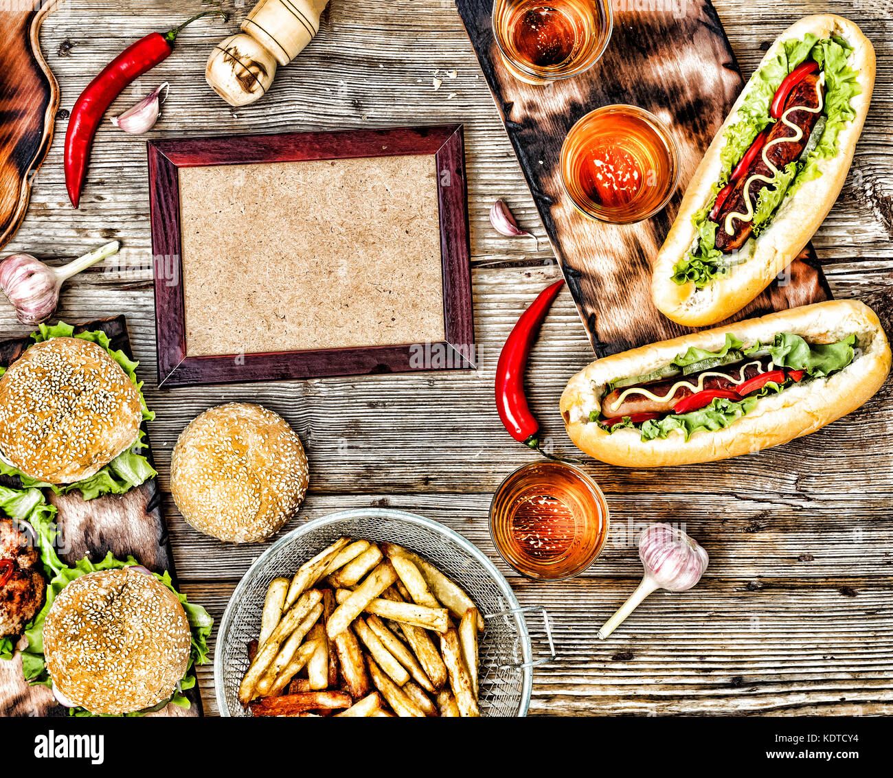 Rustic style, top view homemade burgers with beef, hot dogs and beer on a wooden table. Stock Photo