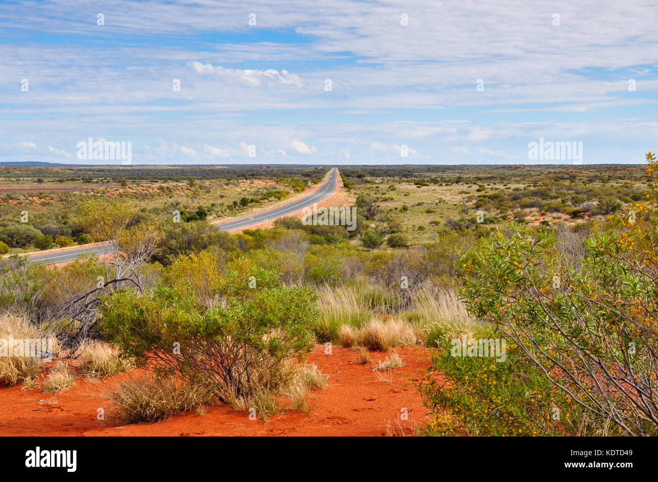 A road disappearing into the distance near Uluru in Australia Stock Photo