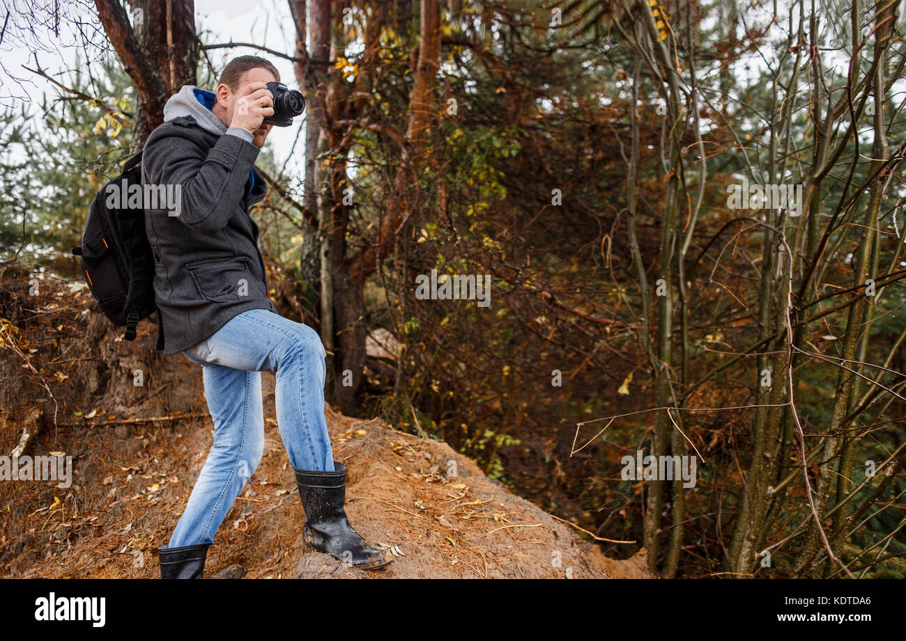 young photographer photographing in autumn forest Stock Photo - Alamy