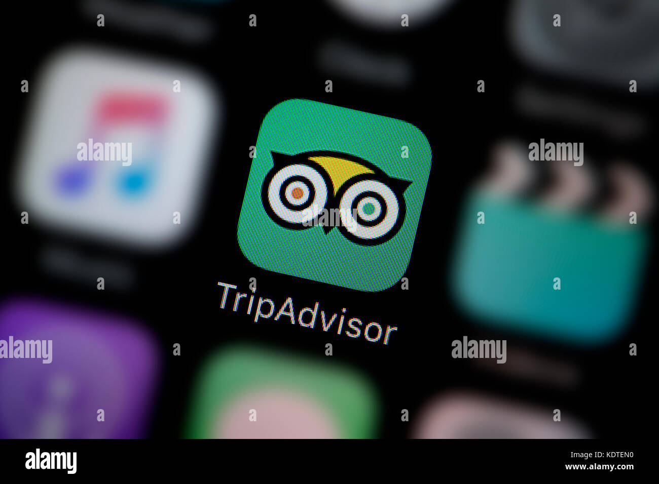 A close-up shot of the logo representing the Trip Advisor app icon, as seen on the screen of a smart phone (Editorial use only) Stock Photo