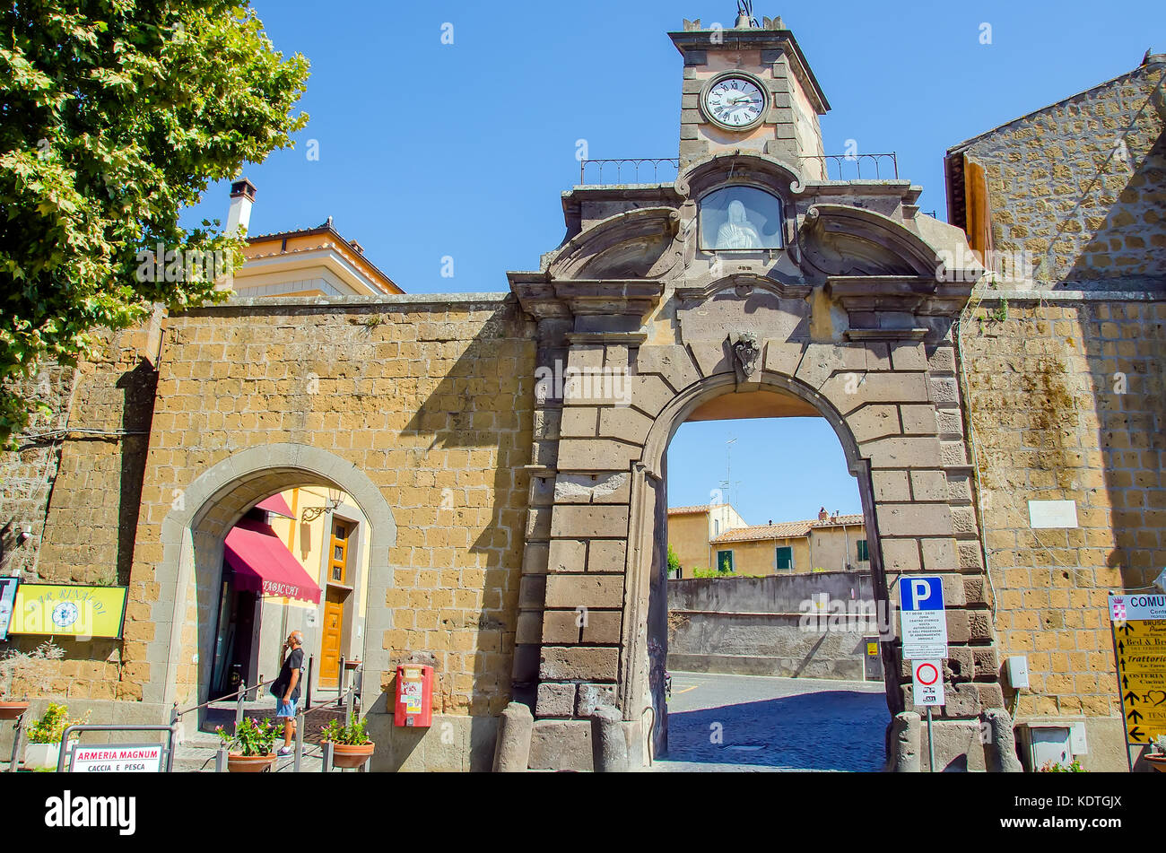 Arched city gate with clock tower, Tuscania, Province of Viterbo, Latium, Italy Stock Photo