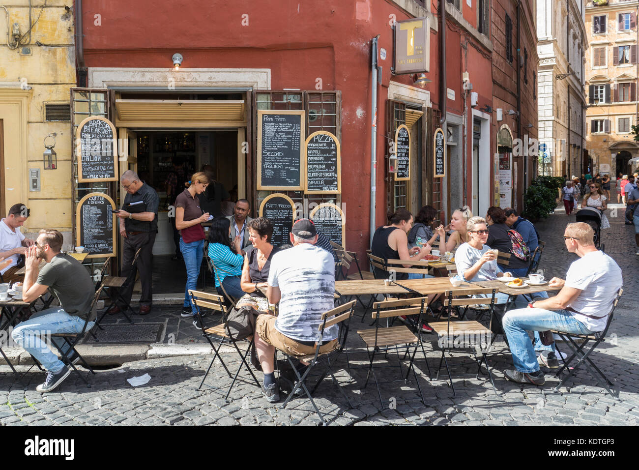 People sat at restaurant tables on a street in Rome, Italy Stock Photo