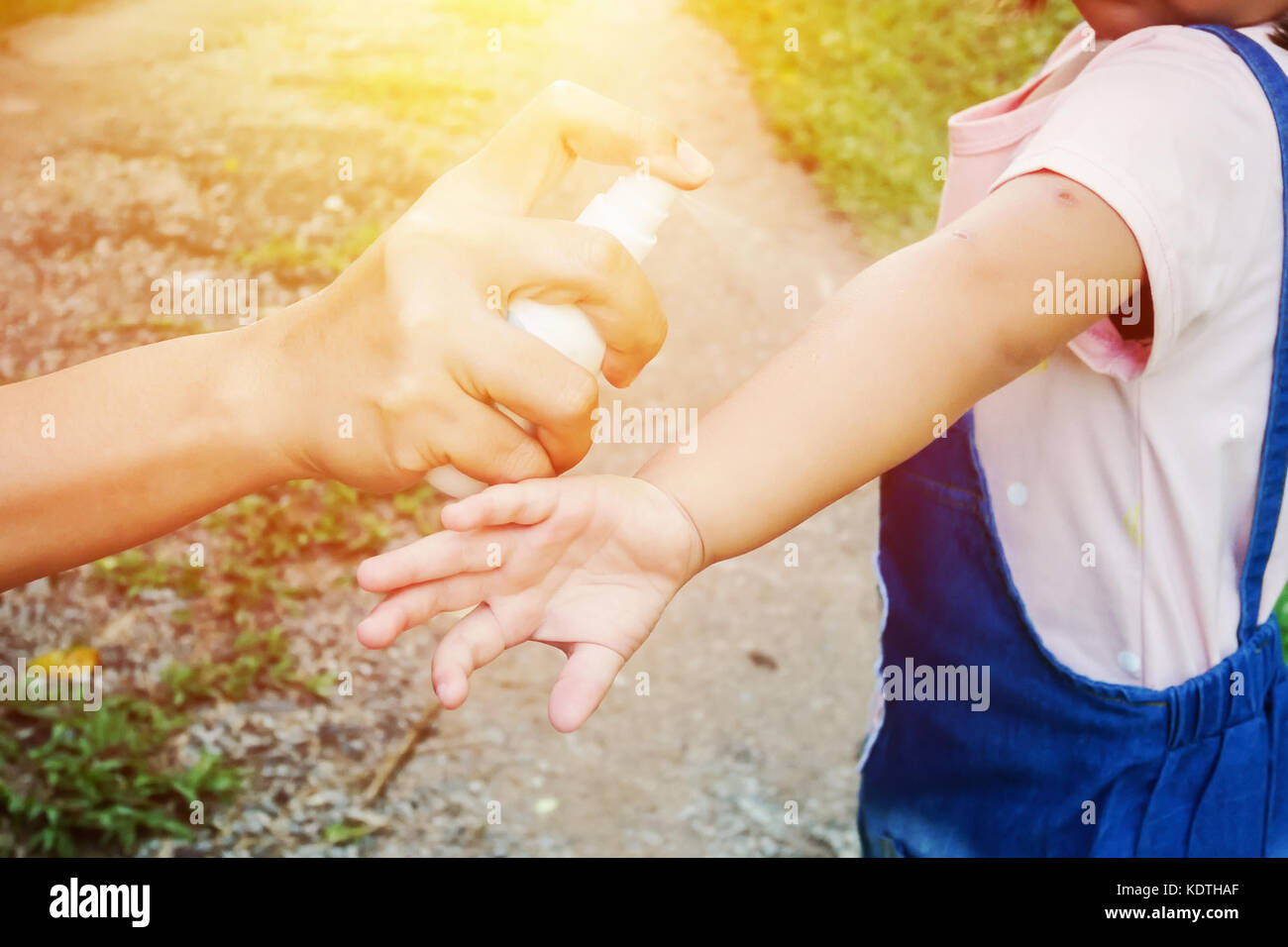 Mother spraying insect or mosquito repellents on skin girl, mosquito repellent for babies Stock Photo