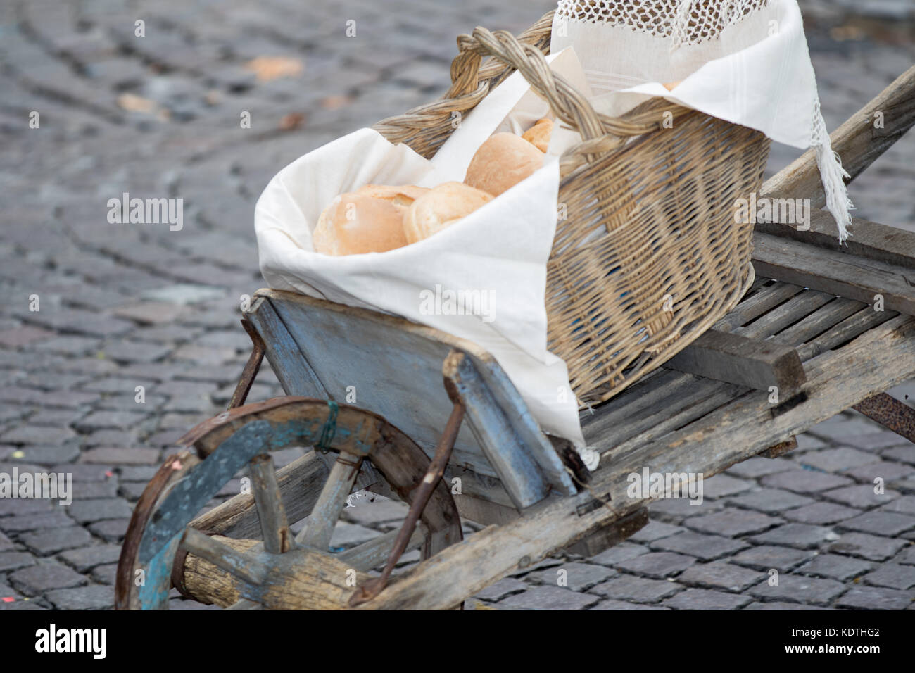 Asti, Italy - September 10, 2017: basket full of bread transported by an old wooden wheelbarrow Stock Photo
