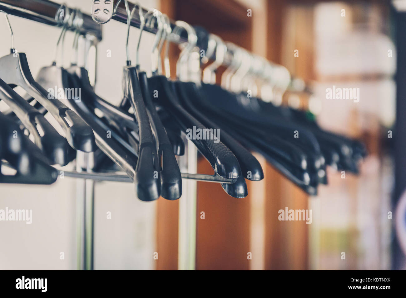 Empty wardrobe stand with black hangers at business event venue. Empty clothing rack at the theatre or business party. Stock Photo