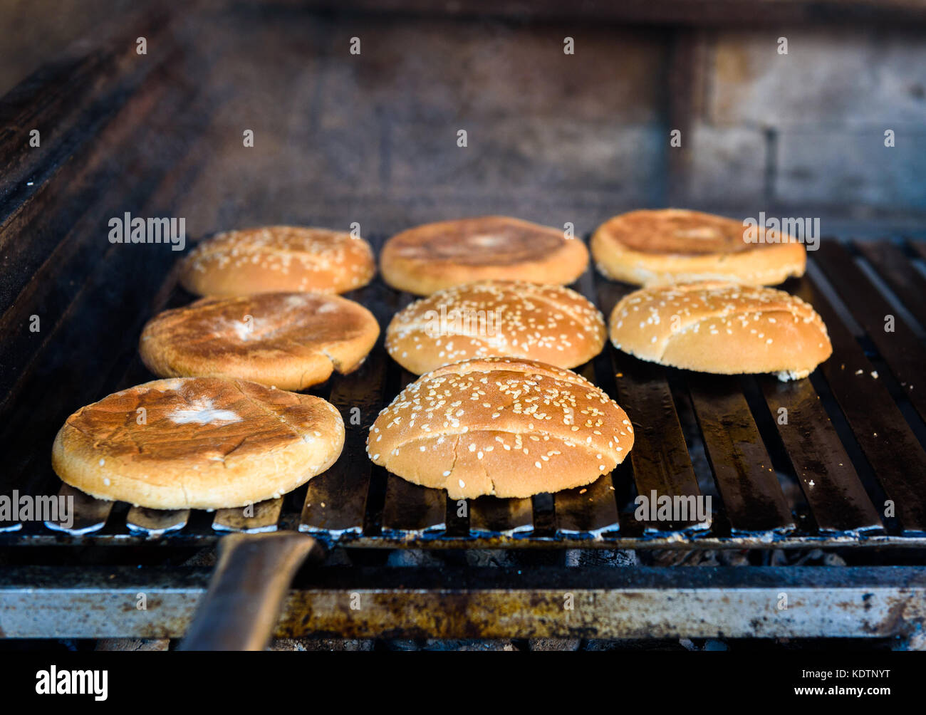 Making and grilling hamburger buns with sesame on coal grill. Preparing  roasted food on barbecue BBQ grill in outdoor fireplace and u-shape fire  grid Stock Photo - Alamy