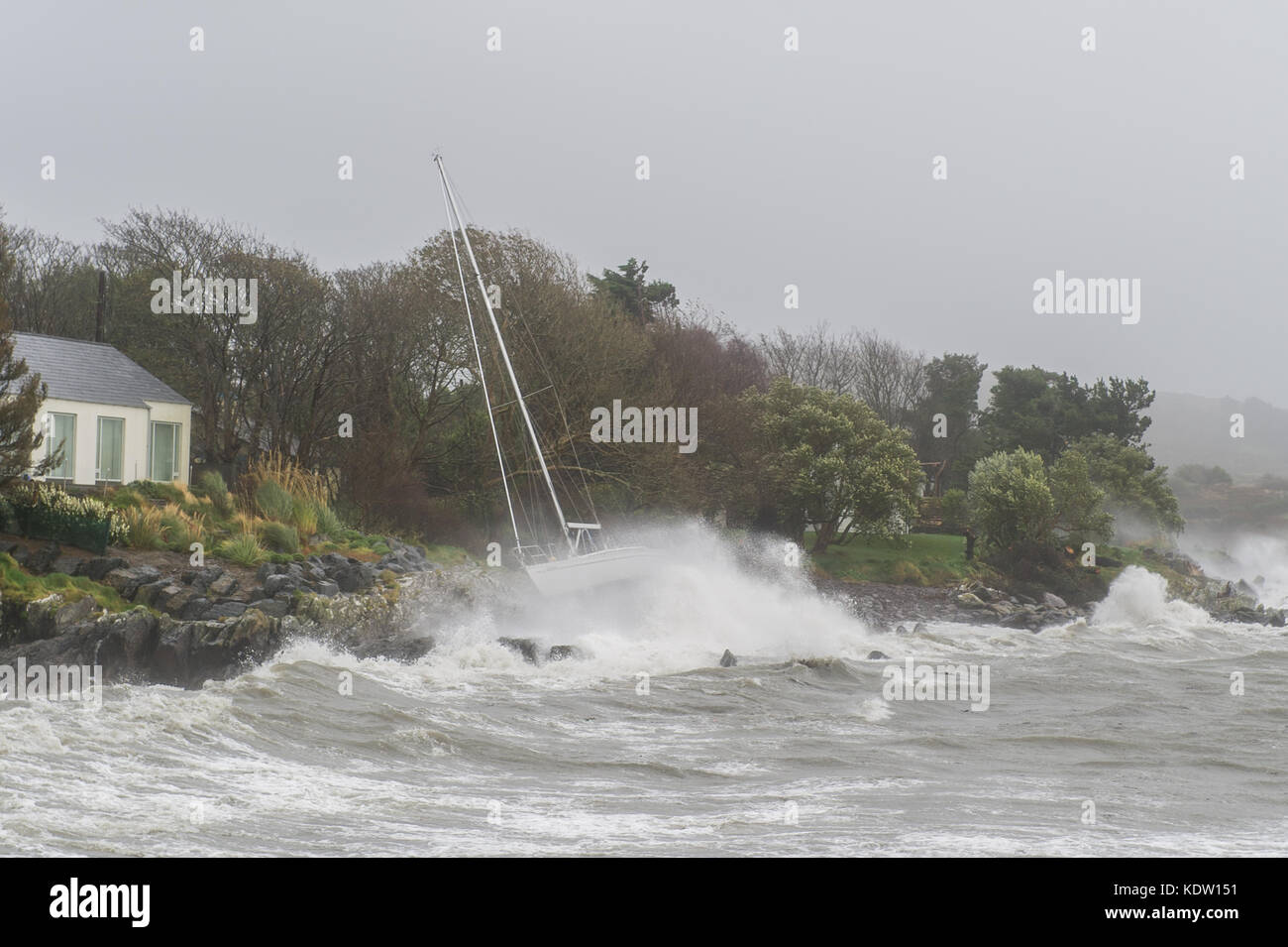 Schull, Ireland 16th Oct, 2017.  Ex-Hurricane Ophelia hits Schull, Ireland with winds of 80kmh and gusts of 130kmh.  Major structural damage is expected as the worst is yet to come. A yacht flounders on rocks after she slipped her moorings due to extremely high winds. Credit: Andy Gibson/Alamy Live News. Stock Photo