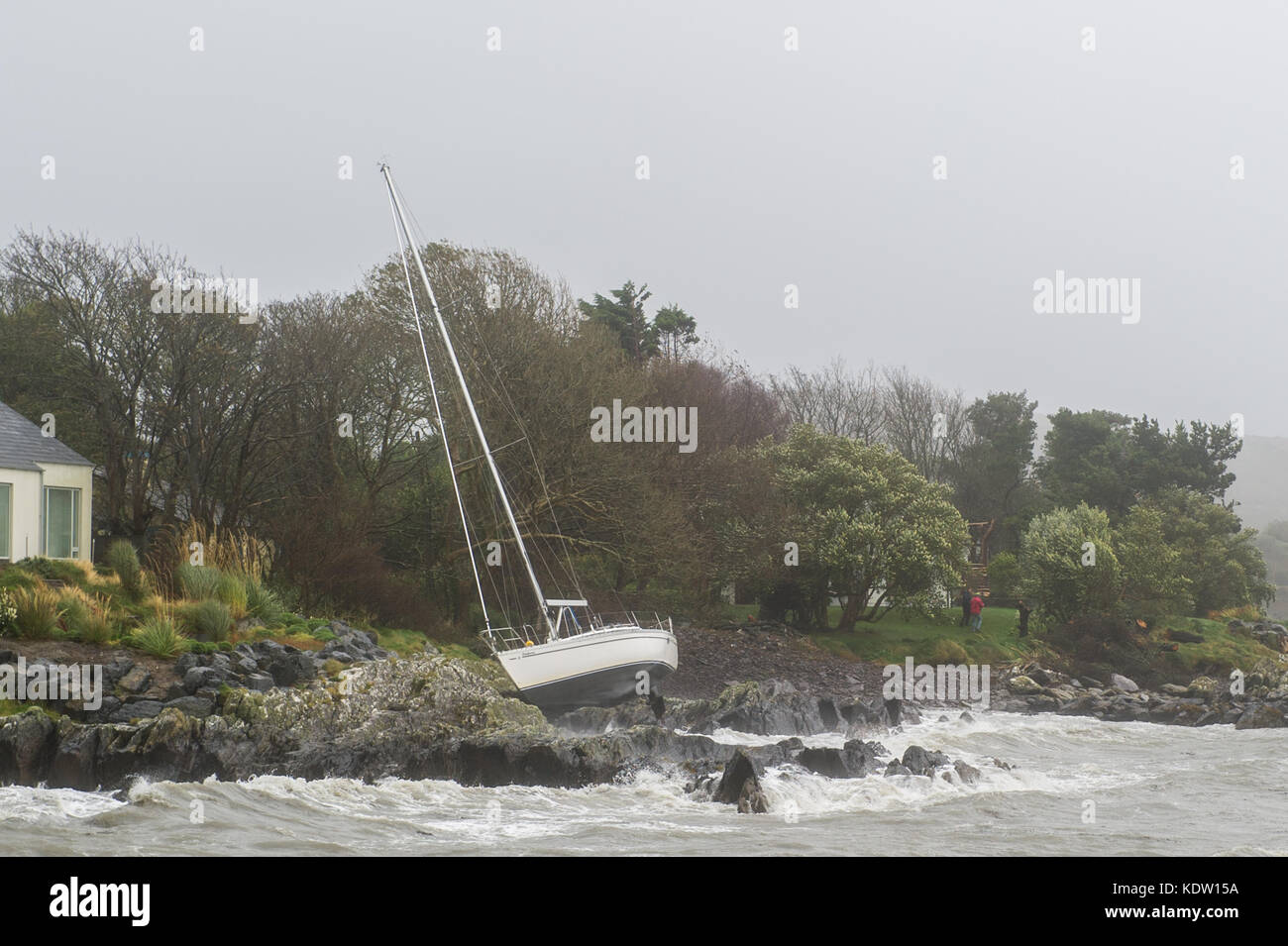 Schull, Ireland 16th Oct, 2017.  Ex-Hurricane Ophelia hits Schull, Ireland with winds of 80kmh and gusts of 130kmh.  Major structural damage is expected as the worst is yet to come. A yacht flounders on rocks after she slipped her moorings due to extremely high winds. Credit: Andy Gibson/Alamy Live News. Stock Photo