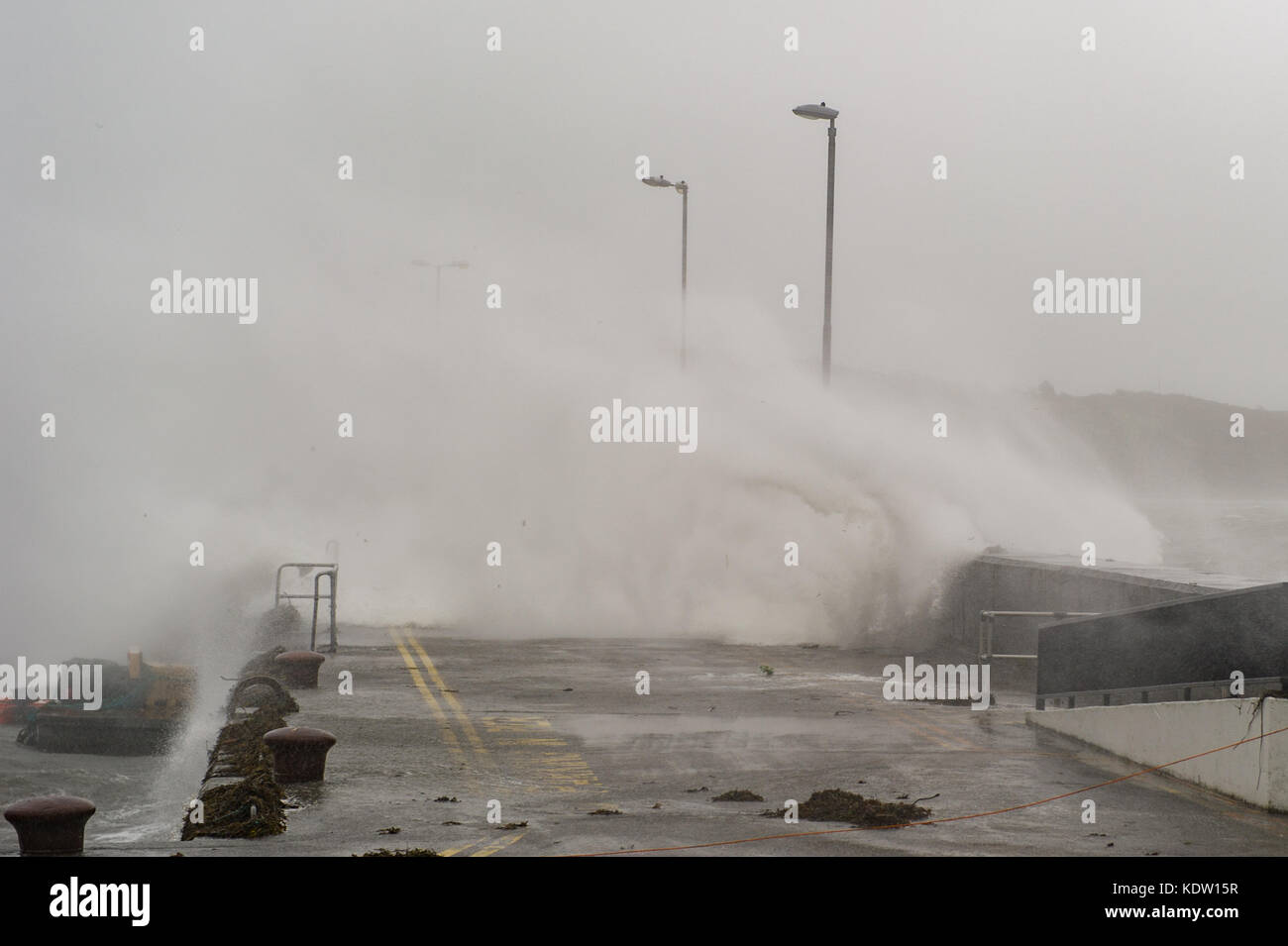 Schull, Ireland 16th Oct, 2017.  Ex-Hurricane Ophelia hits Schull, Ireland with winds of 80kmh and gusts of 130kmh. Waves crash over the Schull pier wall at the height of the hurricane. Credit: Andy Gibson/Alamy Live News. Stock Photo