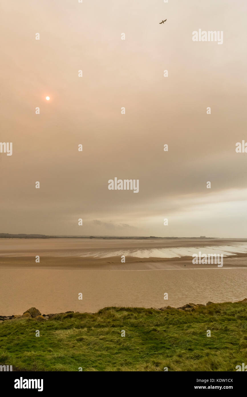 Lydney, Forest of Dean, Gloucestershire, UK. 16th October, 2017.  Mid day red sun, Severn estuary at Lydney, Forest of Dean, Gloucestershire. Credit: David Broadbent/Alamy Live News Stock Photo
