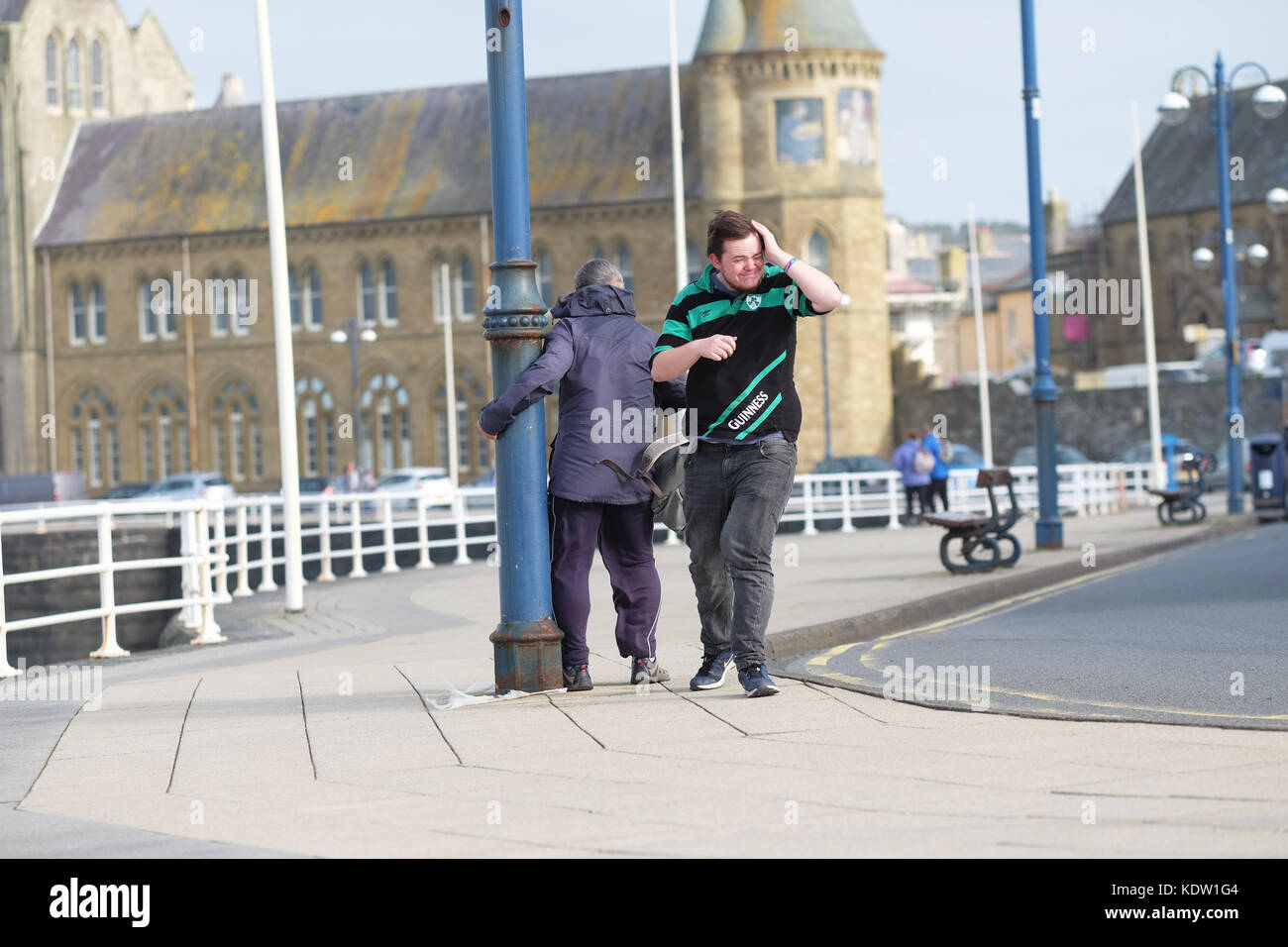 Aberystwyth, Ceredigion, Wales, UK. 16th Oct, 2017. UK Weather. A young man finds it tough going as he turns onto the promenade into the strong winds at Aberystwyth on the West Wales coast as Storm Ophelia approaches off the Irish Sea with local winds exceeding 50mph. Photo Steven May / Alamy Live News Stock Photo