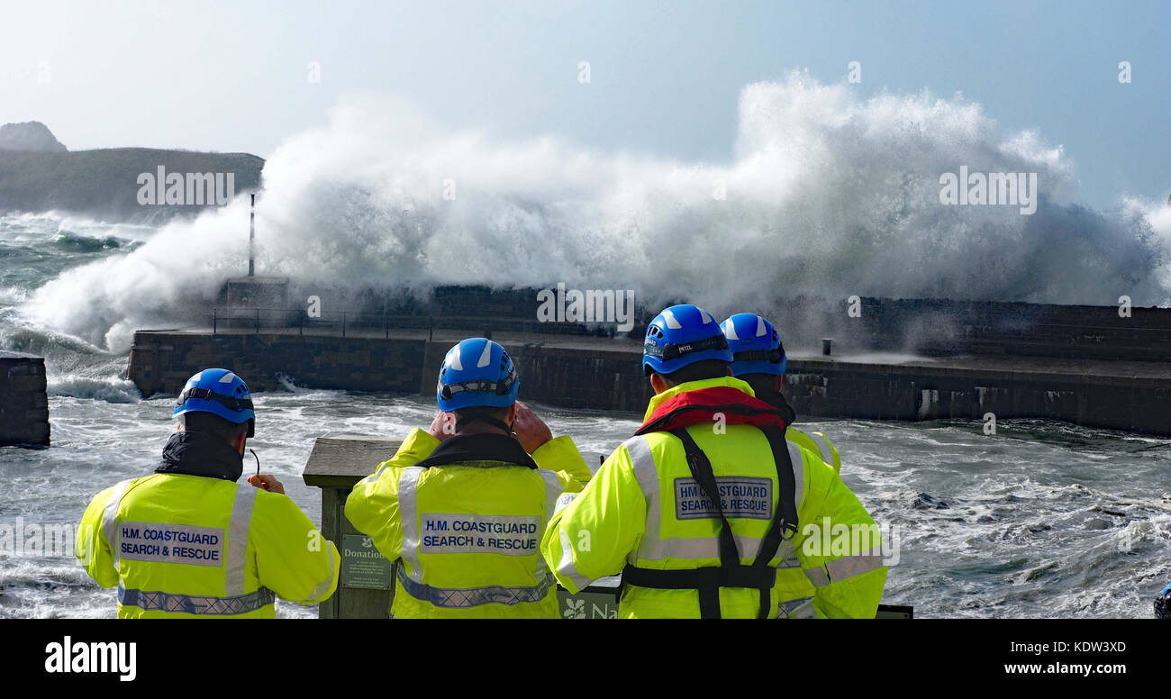 Giant waves sweep into the Cornish coast at Mullion Harbour on The Lizard after the hurricane Ophelia. Coastguards made checks to ensure safety of people around the harbour complex Stock Photo