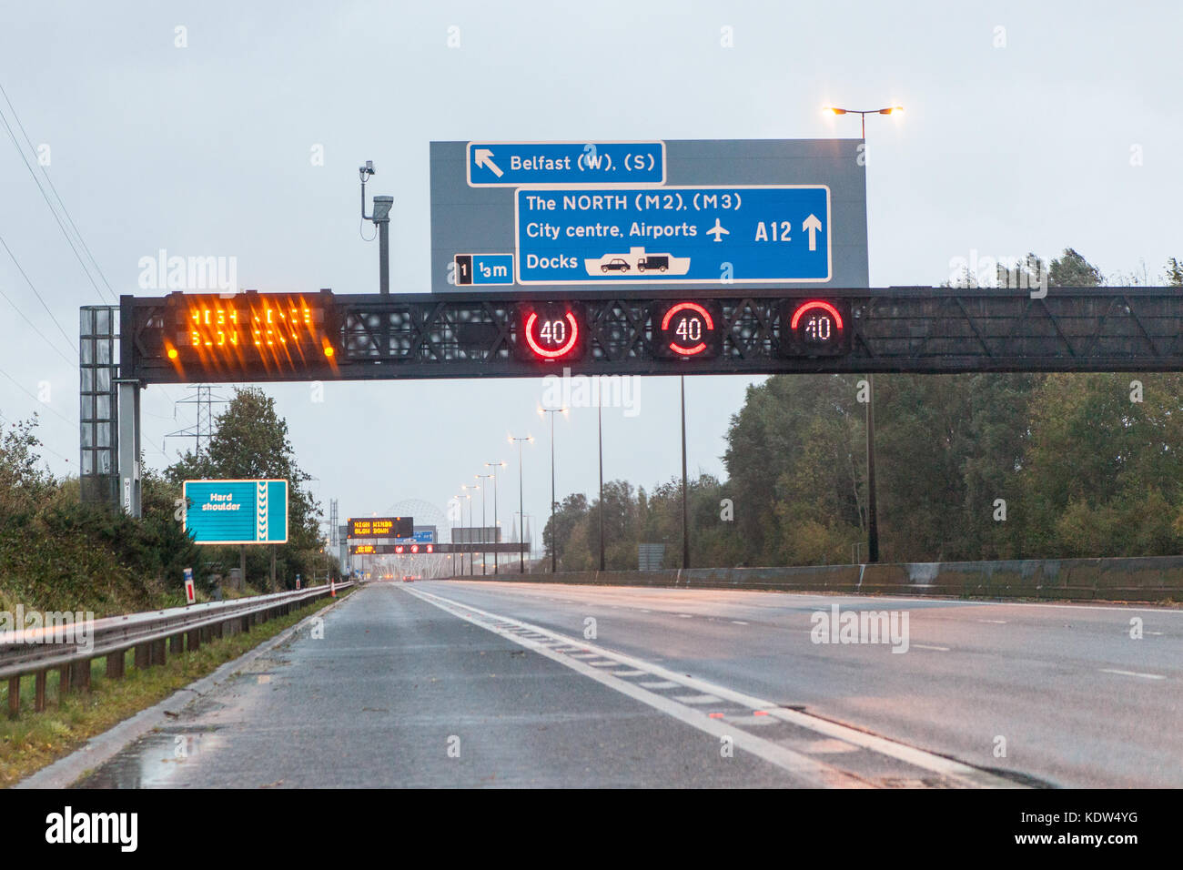 Belfast, UK. 16th Oct, 2017. UK Weather. Warning Message on the gantry on the M1 Motorway heading into Belfast. the sign 'High Winds Slowdown' Storm Ophelia reaches Belfast, Northern Ireland, Trees were felled by the high winds and several roads had a lot of debris on them. Credit: Bonzo/Alamy Live News Stock Photo