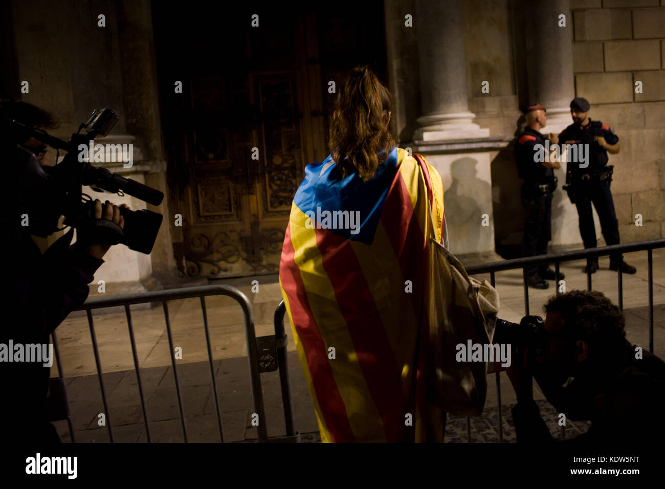 Barcelona, Catalonia, Spain. 16th Oct, 2017. A woman wrapped with a estelada or independentist flag stands in front of Generalitat de Catalunya (Catalan government headquarters) after Spain's High Court has remanded two leaders of a Catalan separatist organization on suspicion of sedition. The leader of the Catalan National Assembly (ANC), Jordi Sanchez, and Jordi Cuixart of the Omnium Cultural group were jailed on Monday after questioning. Credit: Jordi Boixareu/ZUMA Wire/Alamy Live News Stock Photo