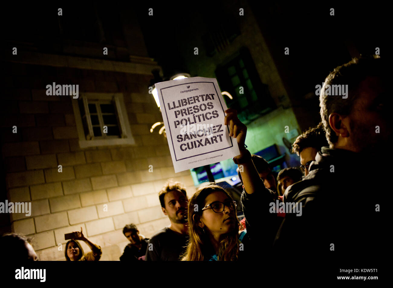 Barcelona, Spain. 16th Oct, 2017. In Barcelona a woman holds a poster reading 'freedom political prisoners Sanchez Cuixart' after Spain's High Court has remanded two leaders of a Catalan separatist organization on suspicion of sedition. The leader of the Catalan National Assembly (ANC), Jordi Sanchez, and Jordi Cuixart of the Omnium Cultural group were jailed on Monday after questioning. Credit: Jordi Boixareu/Alamy Live News Stock Photo