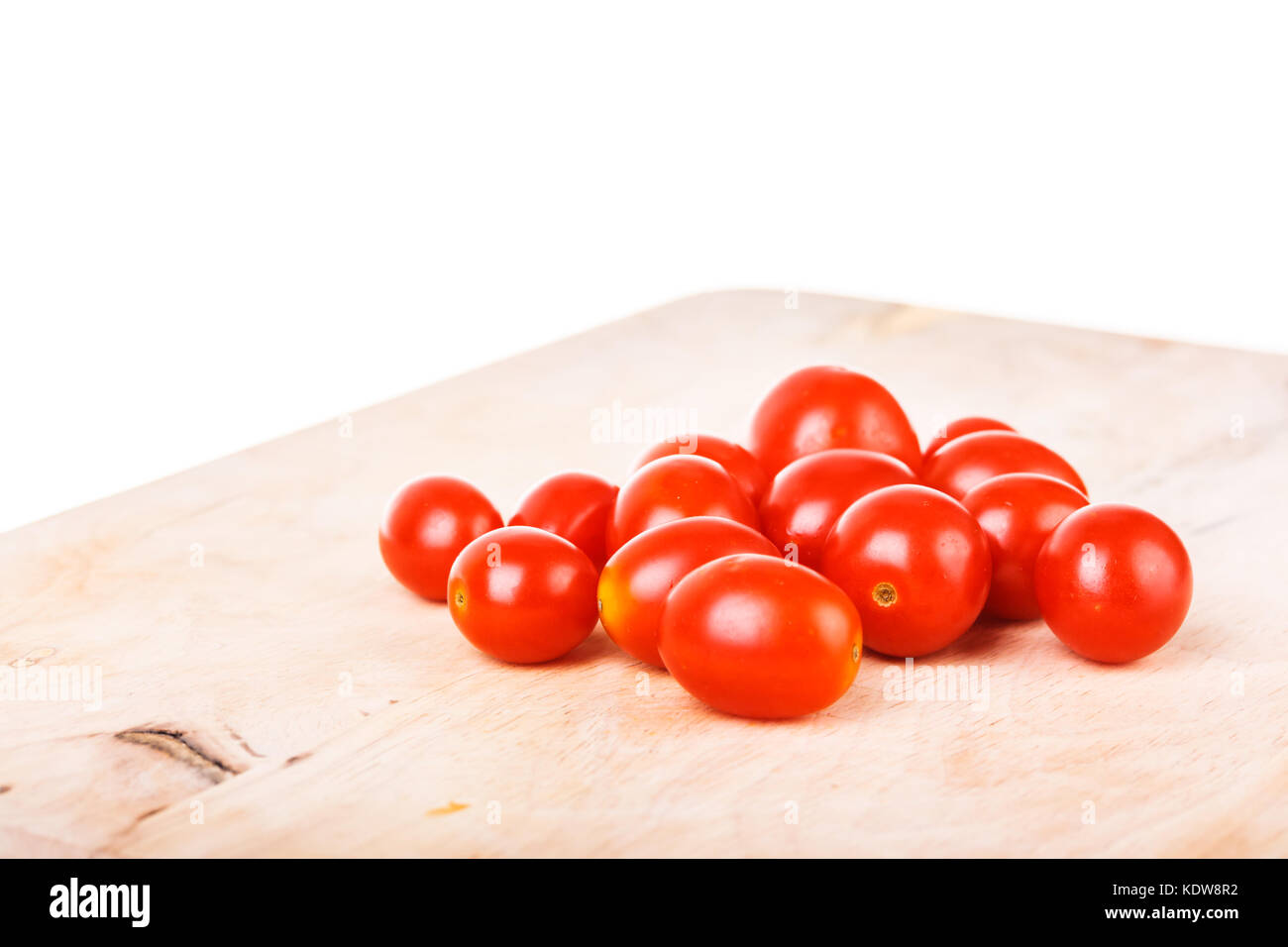 cherry tomatoes on wooden cutting board Stock Photo - Alamy