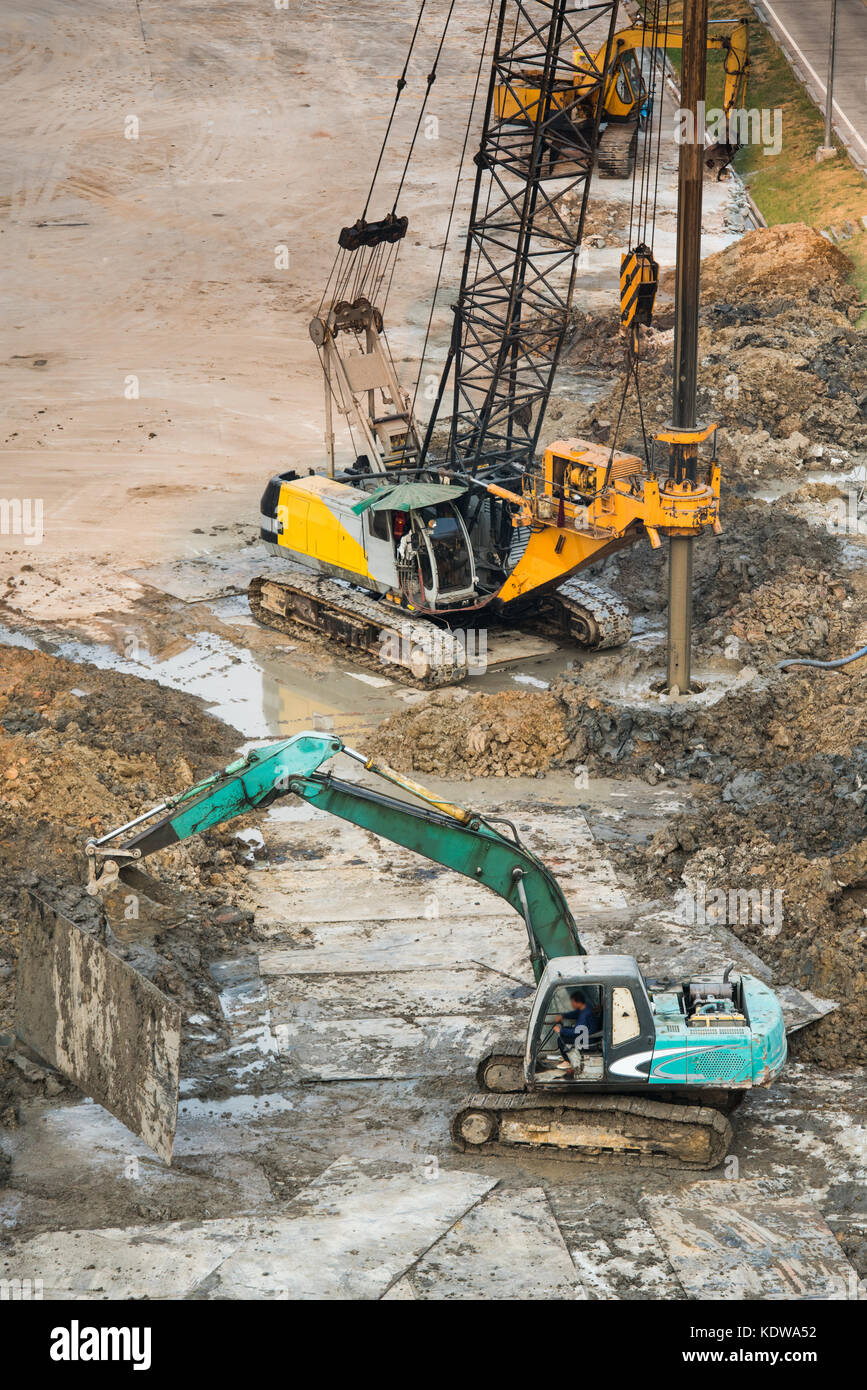 Worker oversee Drilling rigs on ground in construction site Stock Photo