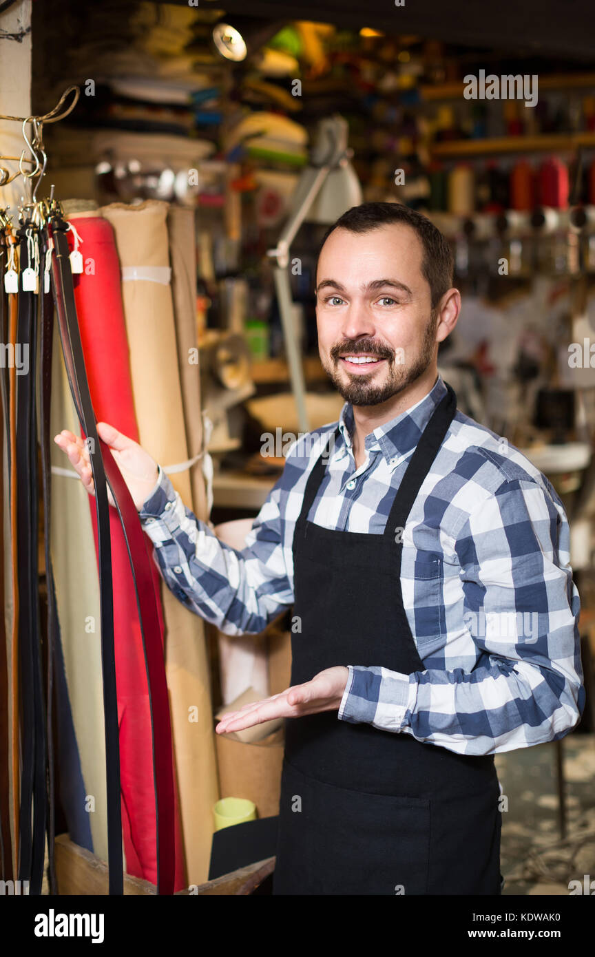 happy man worker displaying various belts in leather Stock Photo Alamy
