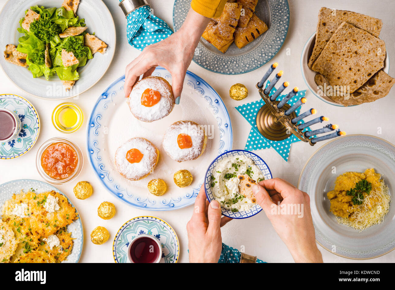 Festive feast on Hanukkah, table setting, hands over table horizontal Stock Photo