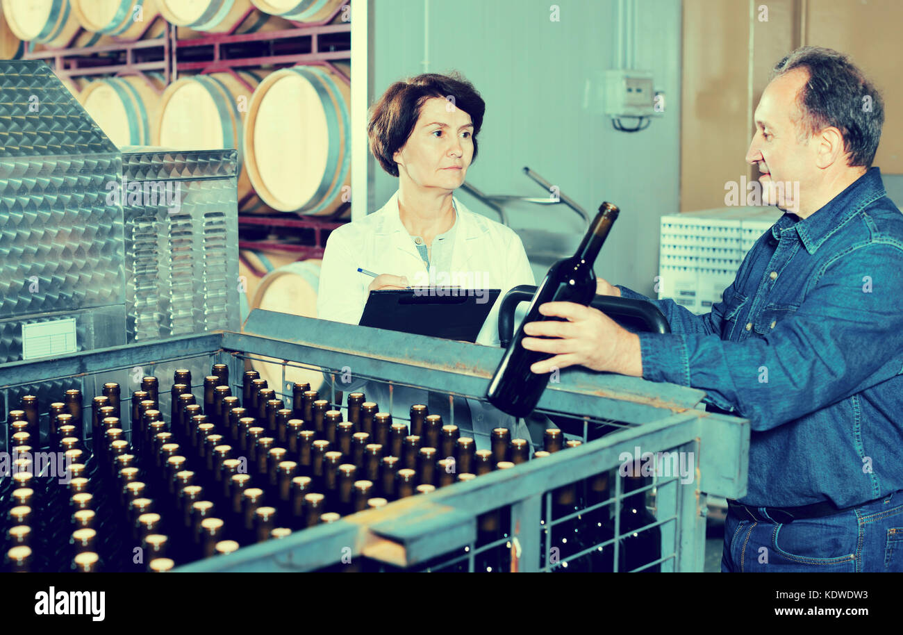 Wine maker showing to expert of the bottles with wine Stock Photo Alamy