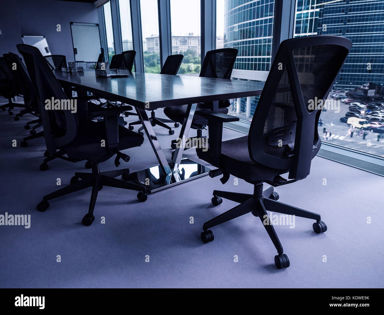 Empty conference room overlooking downtown district, shallow depth of field, blue toned Stock Photo
