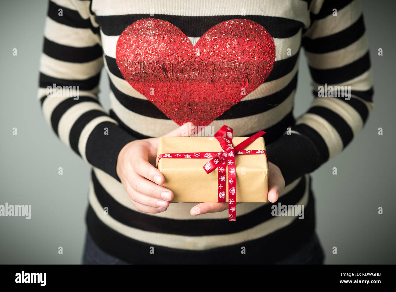 A girl holding a box with a Christmas present Stock Photo - Alamy