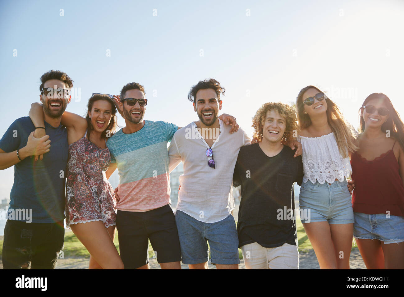 Portrait of group of friends posing together outside laughing Stock ...