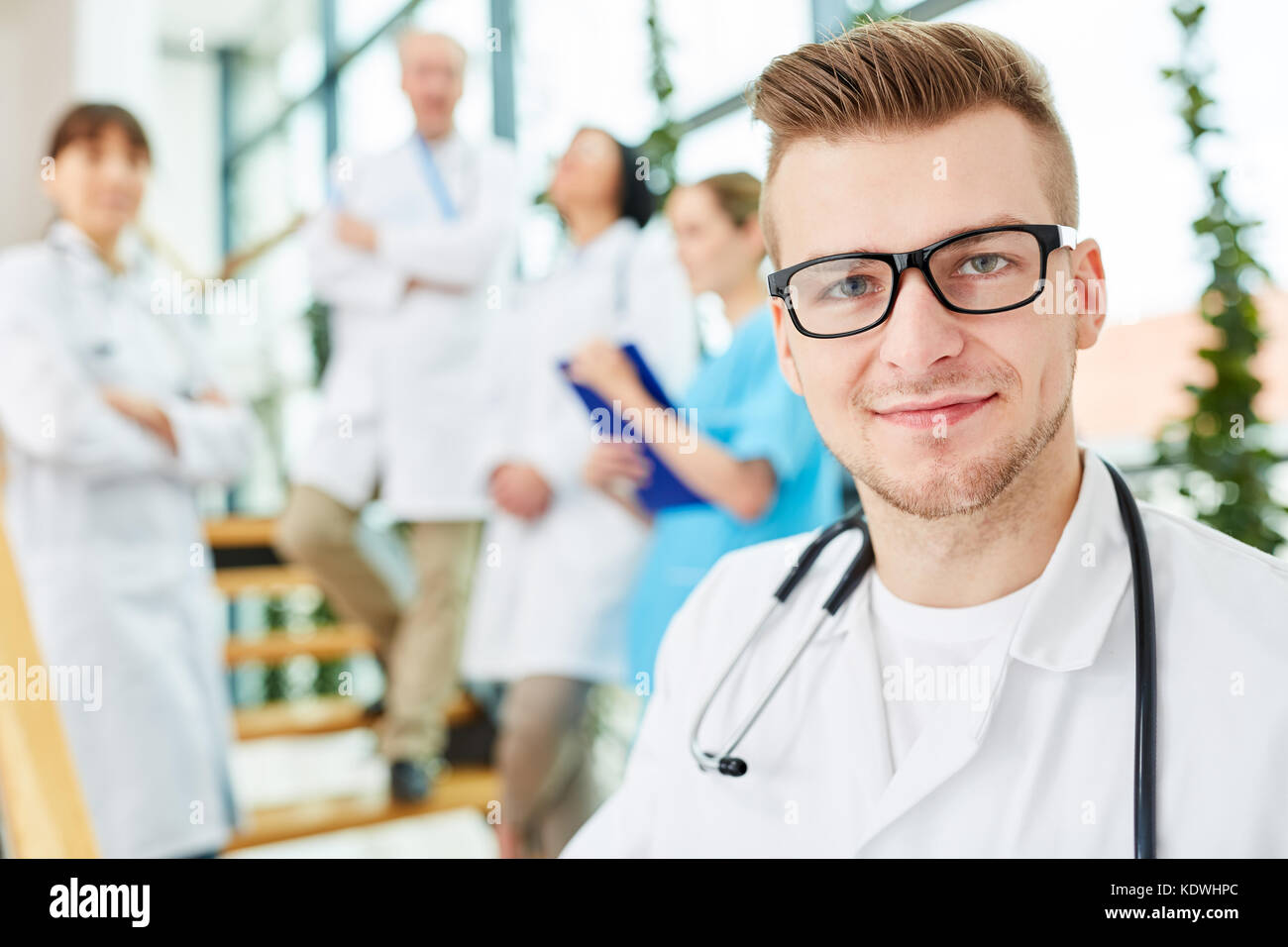 Young physician in medicine apprenticeship with team of doctors Stock Photo
