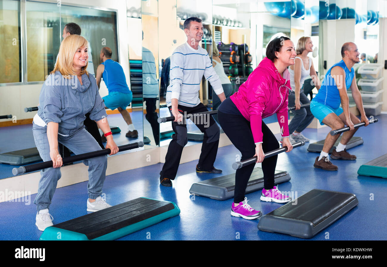 Group of smiling men and women training in a gym Stock Photo - Alamy