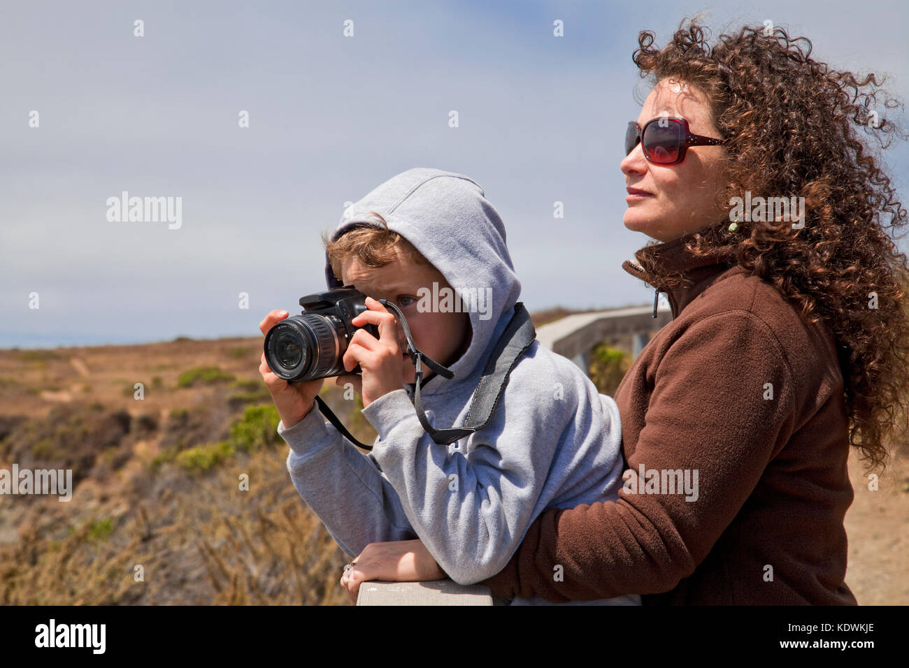 Young boy taking photos with a camera, San Simeon, San Luis Obispo County, California, USA (MR) Stock Photo