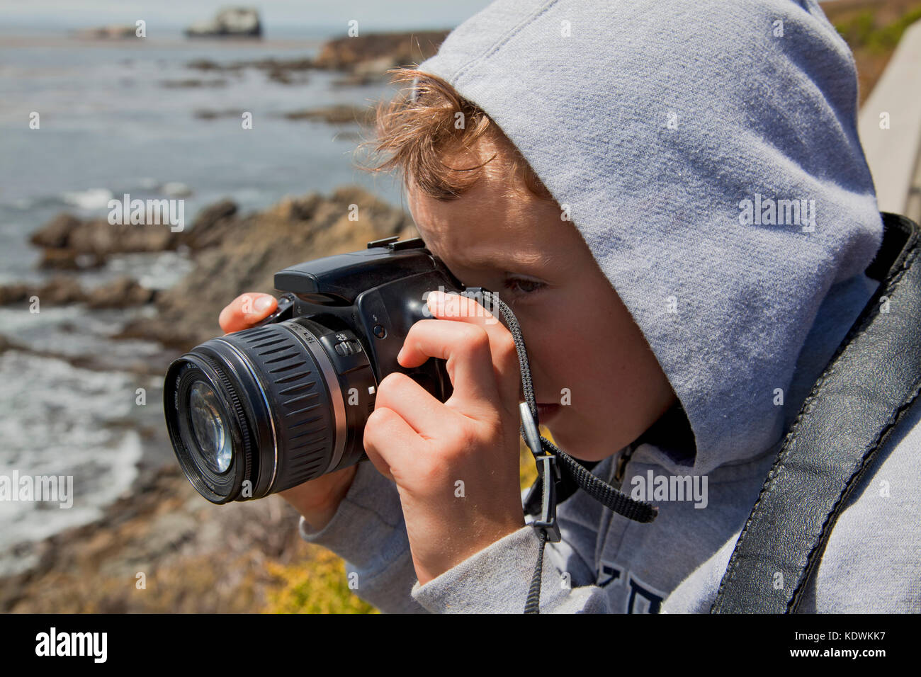 Young boy taking photos with a camera, San Simeon, San Luis Obispo County, California, USA (MR) Stock Photo