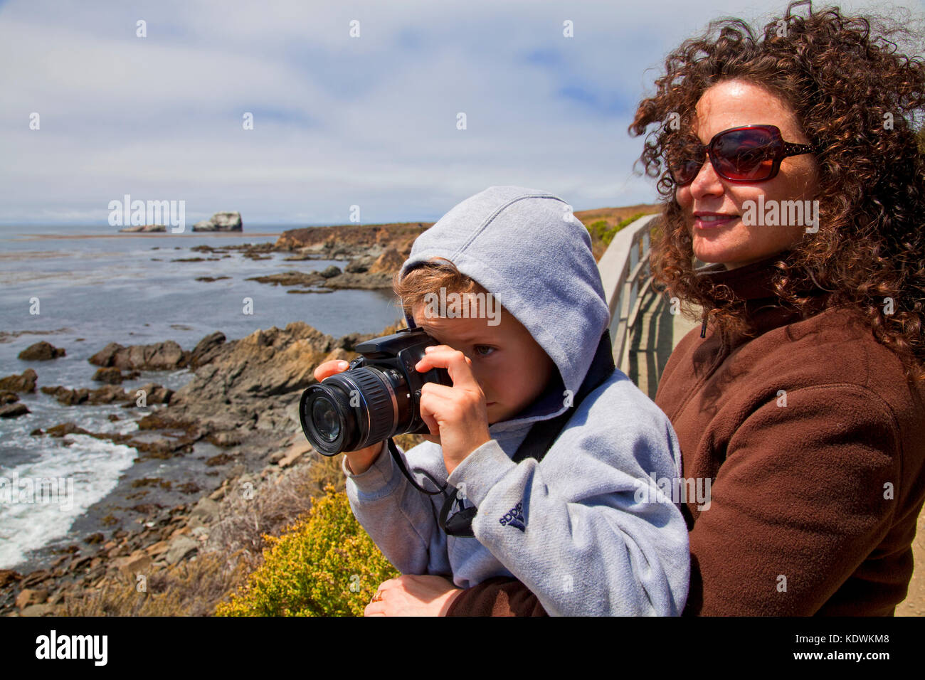 Young boy taking photos with a camera, San Simeon, San Luis Obispo County, California, USA (MR) Stock Photo