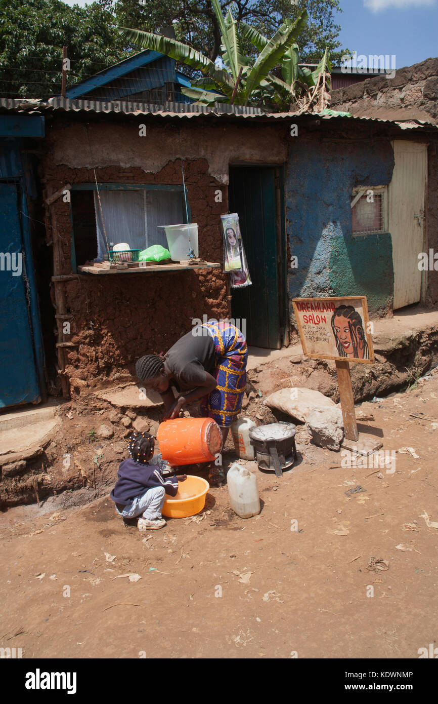 Woman and child washing up outside the dreamland hair salon in Kibera  slums, Nairobi, Kenya, East Africa Stock Photo - Alamy