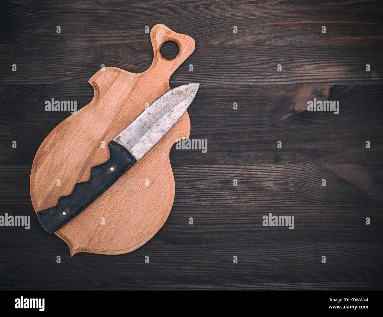 wooden cutting board and old knife on a brown wooden background, empty ...