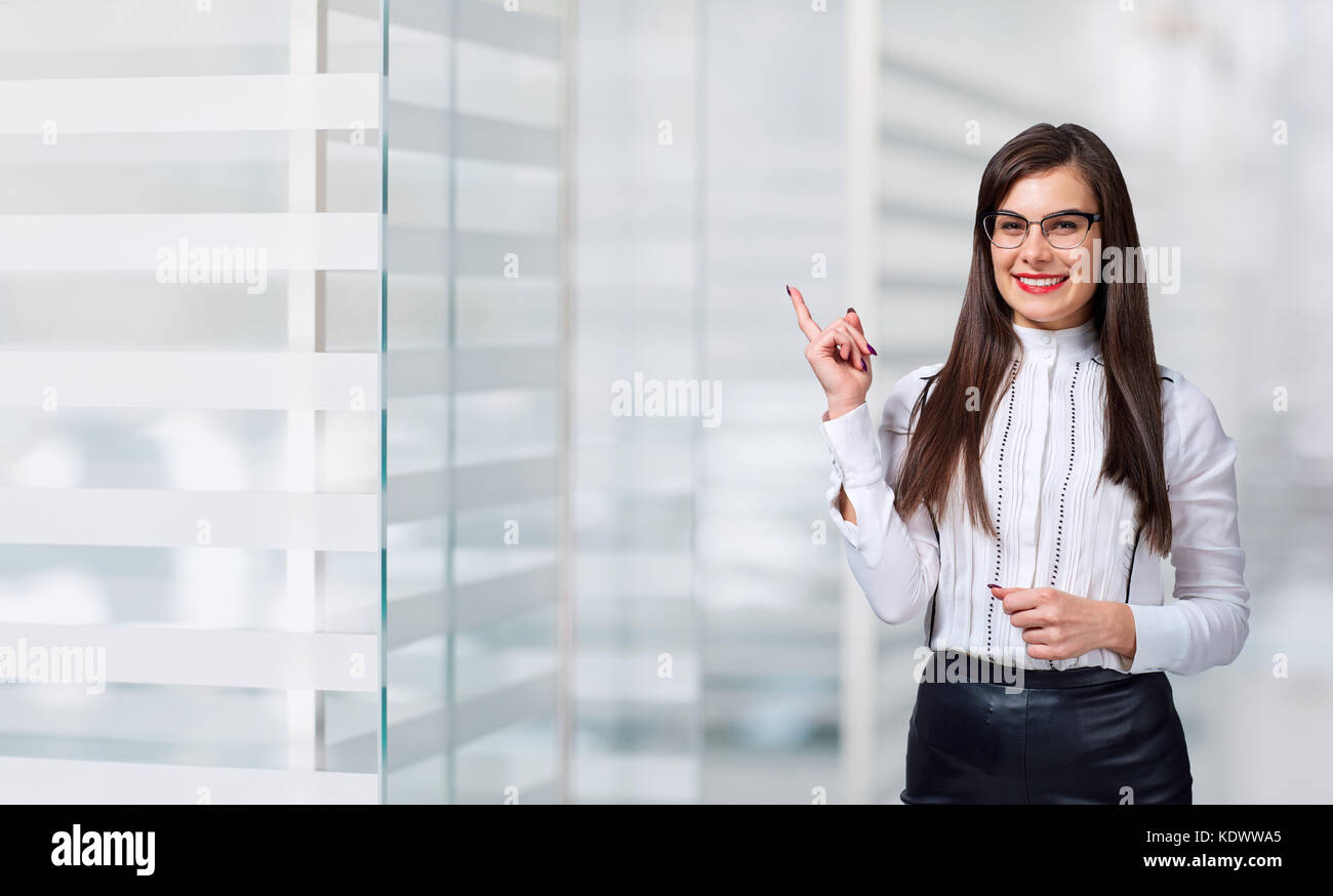 Businessman smiling  pointing in place for text on office backgr Stock Photo