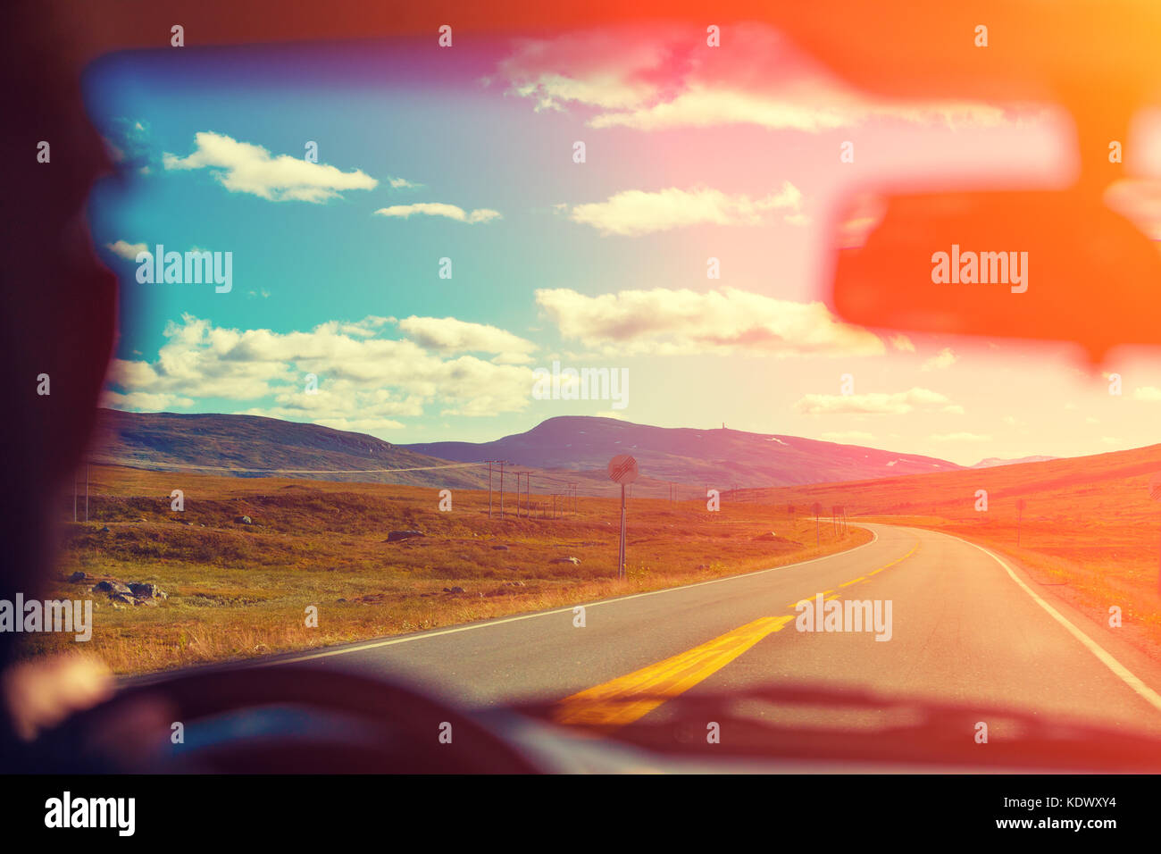 Driving a car on the mountain road at sunset. View from the windscreen ...